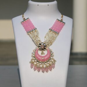 Pink meenakari chand bali kundan and pearls necklace set with maang tikka and earrings.